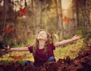 Child in pile of leaves